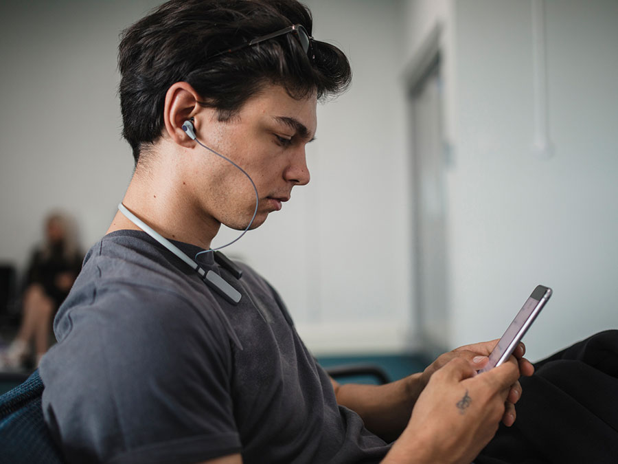 Traveller using bluetooth earphones in an airport