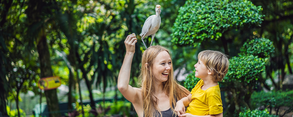 Woman holding son with bird on head